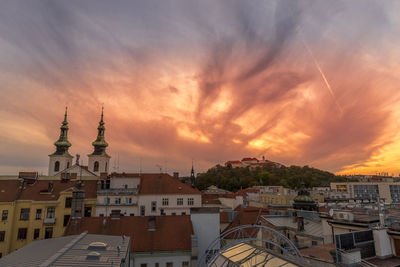 Buildings in town against sky during sunset
