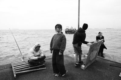 People sitting on beach against sky