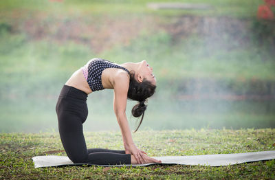 Woman doing yoga on field