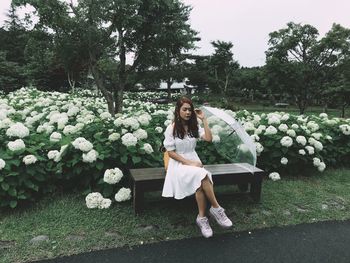 Full length of woman with white flowers