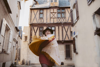 Portrait of woman with shawl standing in city