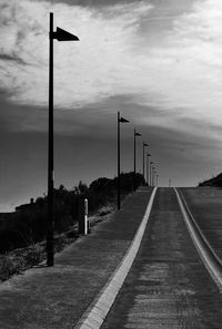 Empty road against cloudy sky