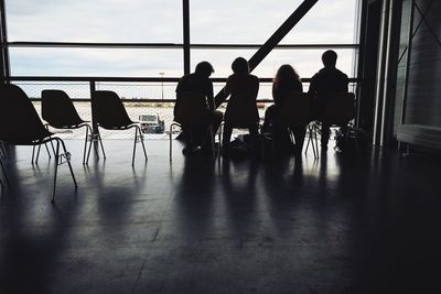 Silhouette people sitting on chair at departure area in bremen airport
