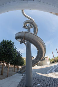 Low angle view of street light by building against sky