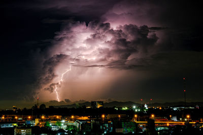Panoramic view of lightning over city at night