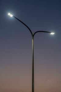 Low angle view of illuminated street light against clear sky