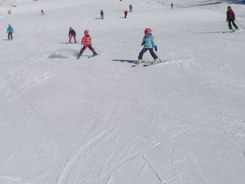 People skiing on snow covered field