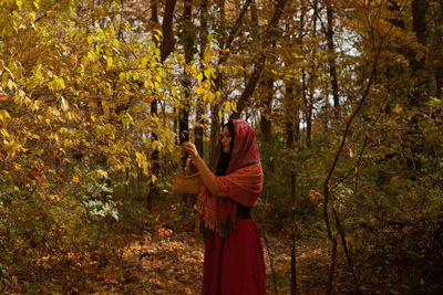 Rear view of woman standing in forest