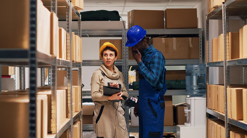 Portrait of young woman standing against building