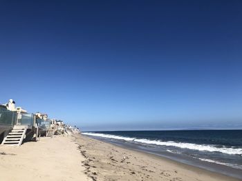 Scenic view of beach against clear blue sky