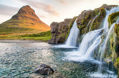 Scenic view of waterfall against sky