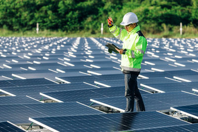 Asian engineer with digital tablet  in his hand who plans to expand the plant with solar panels. 