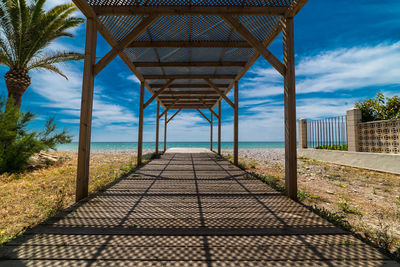 View of walkway by sea against sky