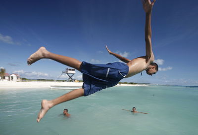 Full length of woman jumping on beach