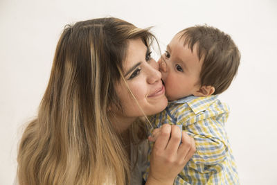 Close-up of mother and daughter against white background