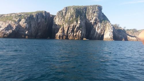 Scenic view of rock formation in sea against sky
