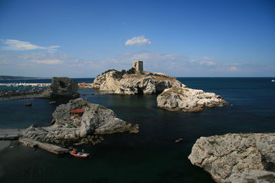 Rocks in sea against sky