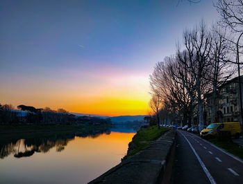 Road passing through city at sunset