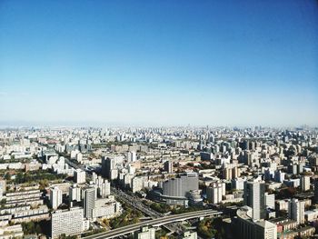 High angle view of city buildings against clear blue sky