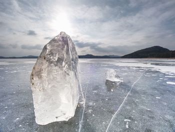 Winter view of the frozen sea to the opposite bank. the sun in ice colorful glare. icicle on beach