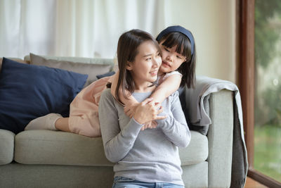 Happy mother and daughter sitting on floor