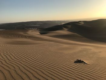 Scenic view of peruvian desert against sky during sunset.