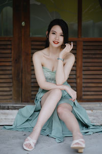 Portrait of young woman sitting on hardwood floor