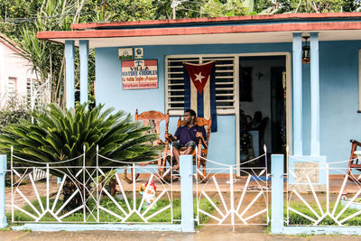 People standing outside house against building