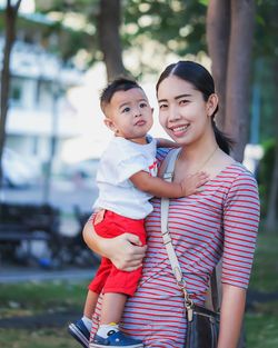 Portrait of mother carrying son