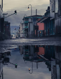 Reflection of buildings in puddle on street