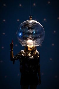 Woman standing under spherical light