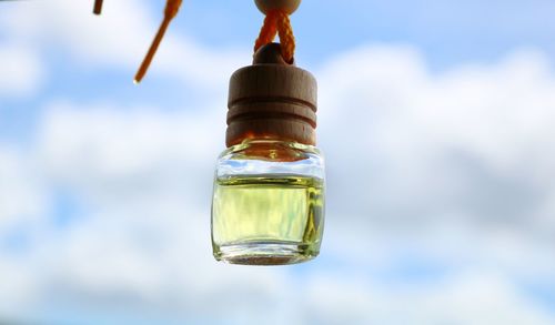 Close-up of bottle in water against sky