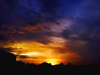 Silhouette of trees against dramatic sky