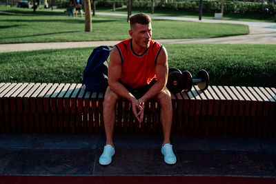 Portrait of young man exercising on bench