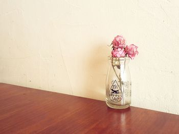 Close-up of vase on table against wall at home