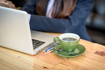 Close-up of woman using laptop on table