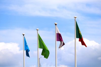 Low angle view of flags hanging against sky