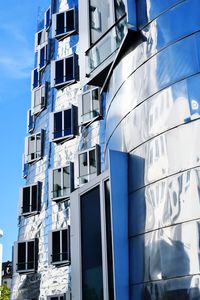 Low angle view of modern building against blue sky