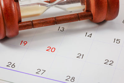 Close-up of hourglass on calendar