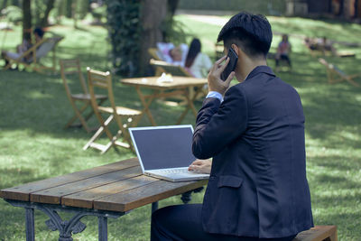 Side view of man sitting on bench