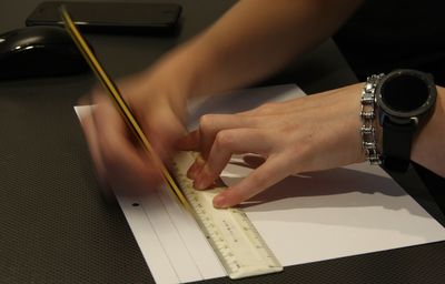 High angle view of hand holding paper on table