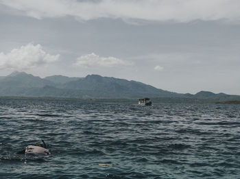 Scenic view of sea against sky and snorkeling activity