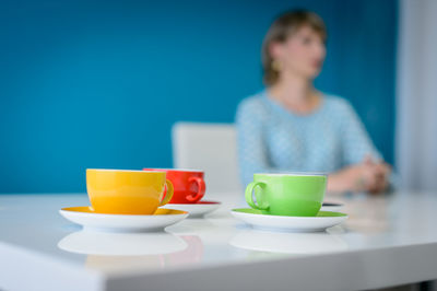 Woman sitting by coffee cup on table