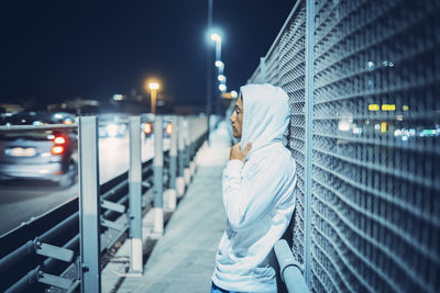 Low angle view of man standing in city at night