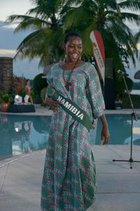 Portrait of a smiling young woman standing at swimming pool