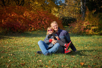 Portrait of smiling man sitting on plants during autumn