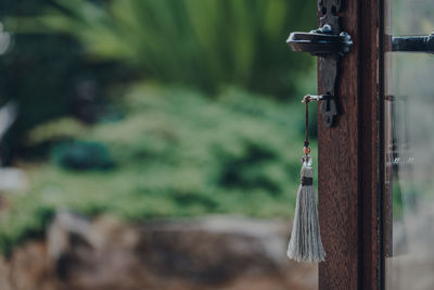 Key with a tassel key ring in the open door leading to the garden, selective focus.