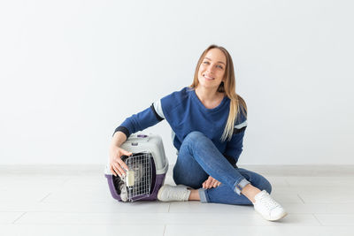 Portrait of a smiling young woman sitting on floor