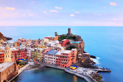 High angle view of cityscape by sea against sky