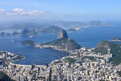 High angle view of city by sea against sky